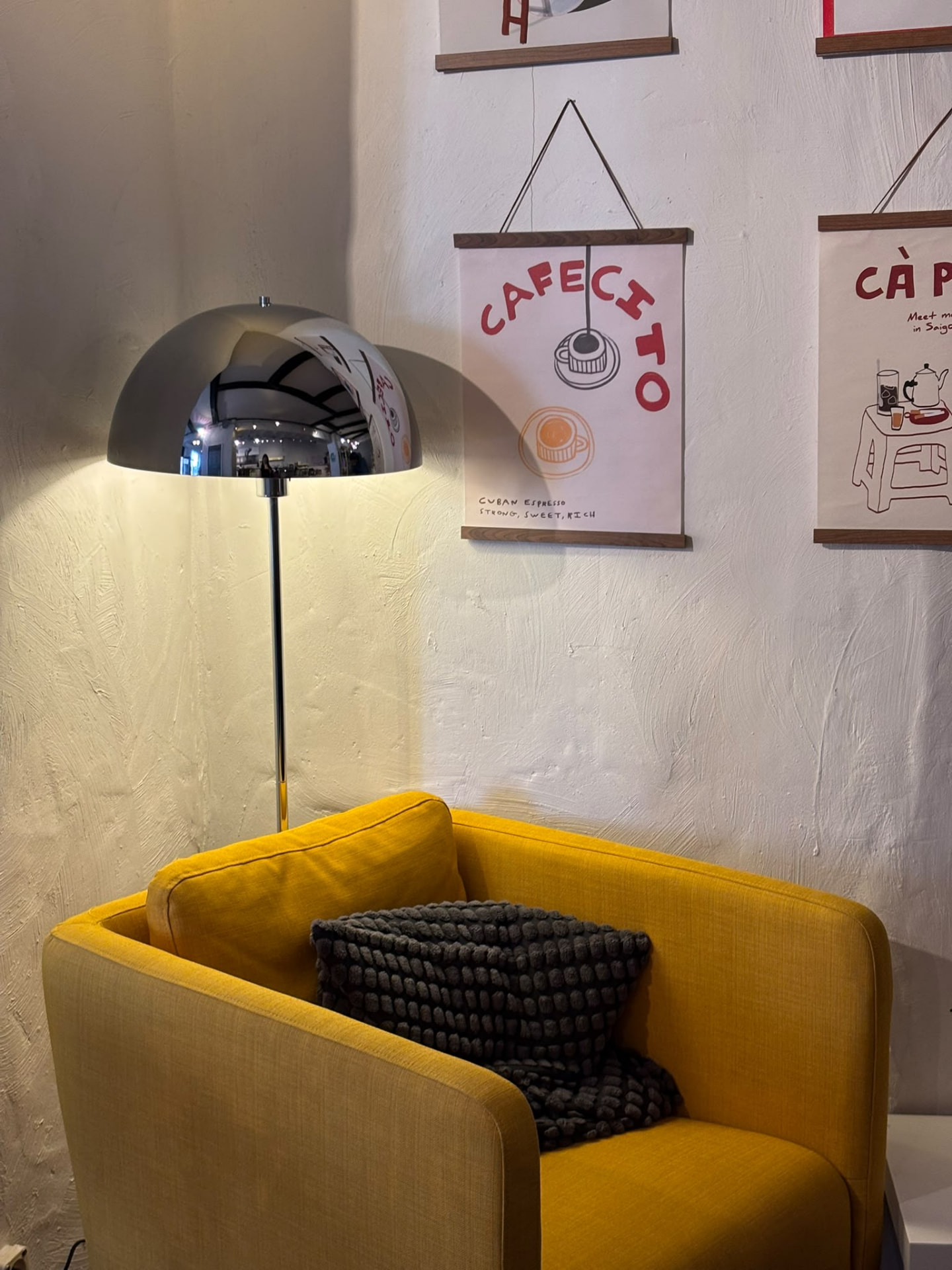 De gele fauteuil met leeslamp in een hoek van de winkel